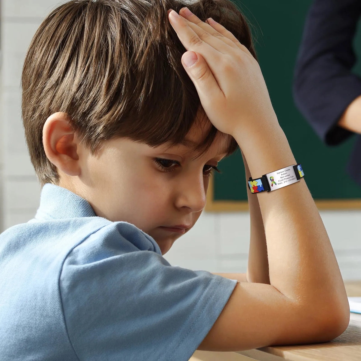 child wearing a black and white personalized autism bracelet featuring a puzzle pattern. with custom text.