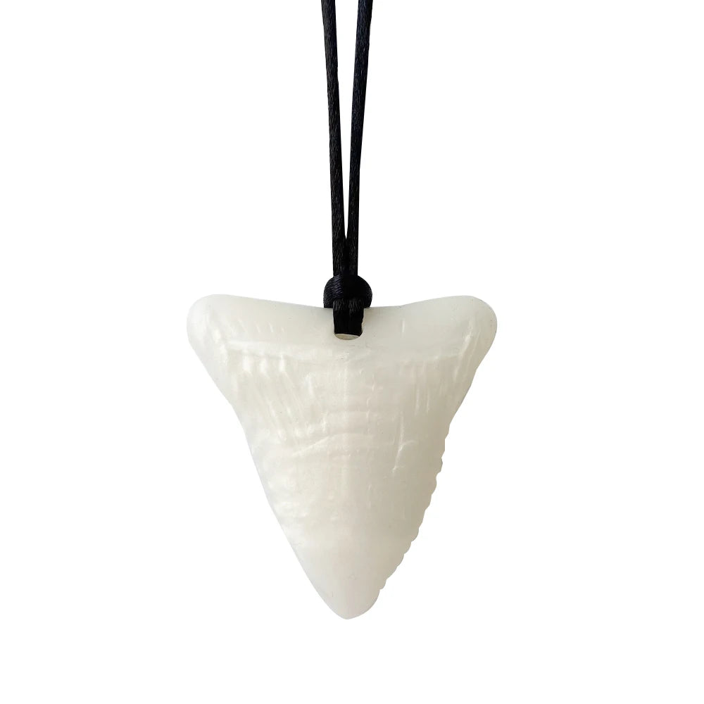 Shark tooth pendant on a black cord against a white background