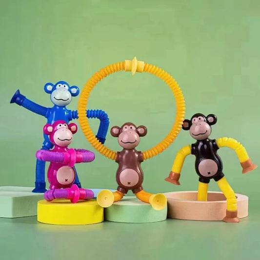 Colorful monkey-themed stretchy pull tube fidget toys on a green backround