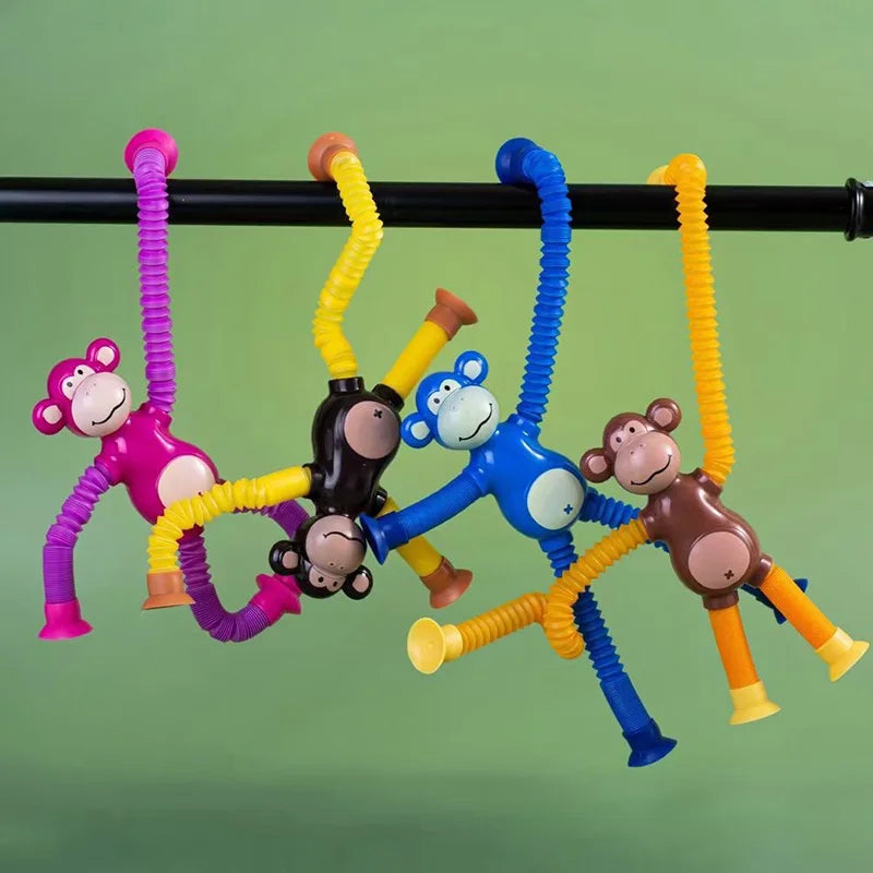 Colorful monkey-themed stretchy pull tube fidget toys hanging from a pole