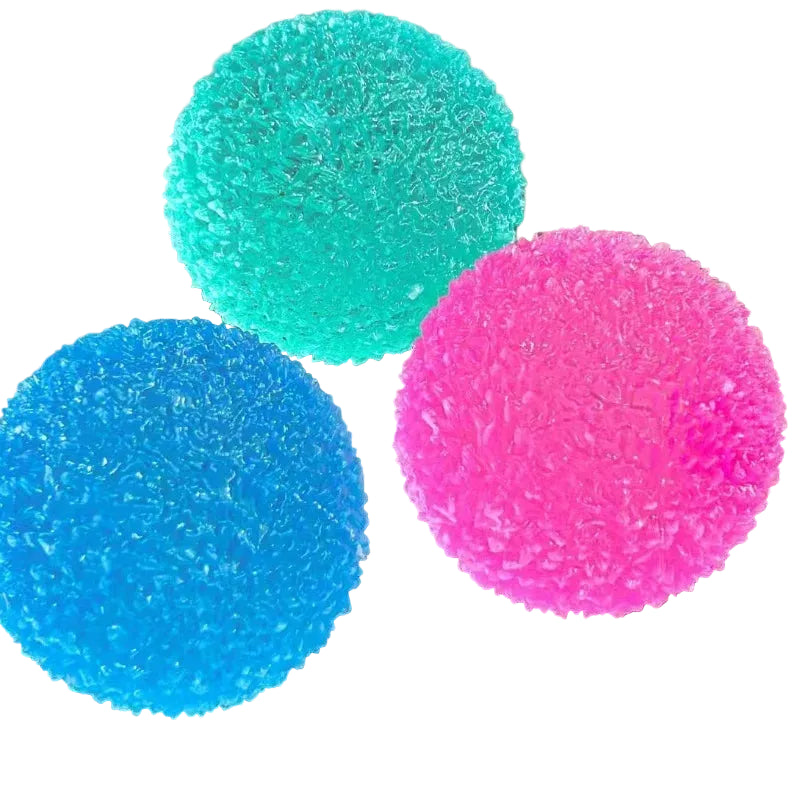 Three textured stress balls in blue, green, and pink on a white backround