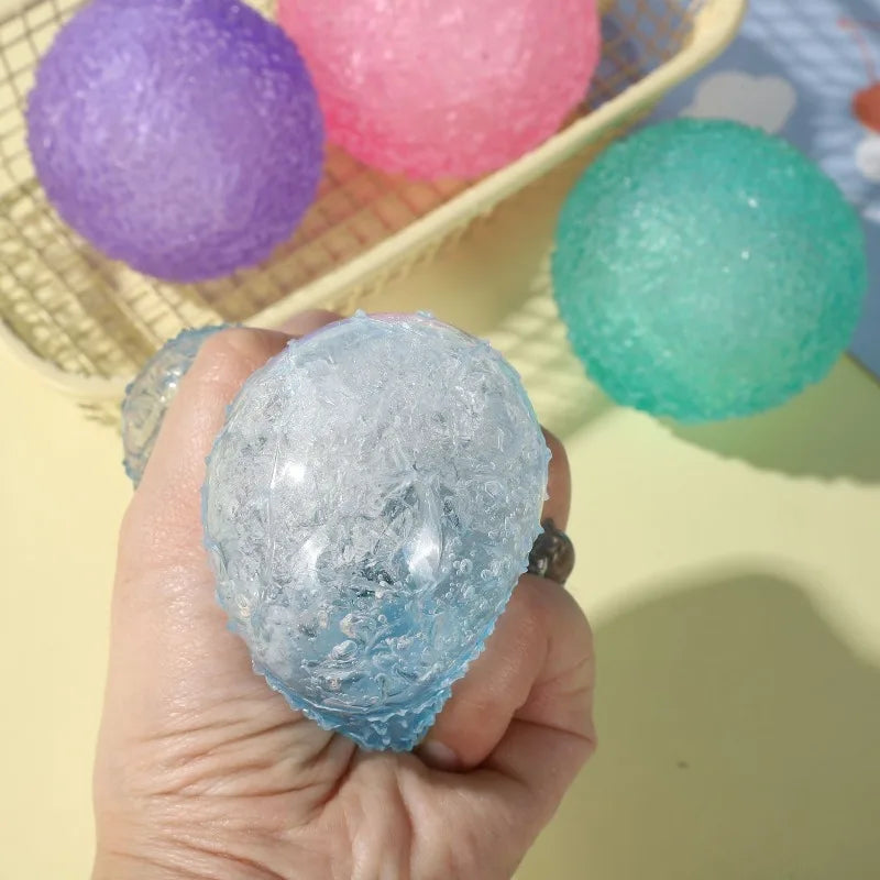 Hand squeezing a blue textured stress ball with colorful stress balls in the background