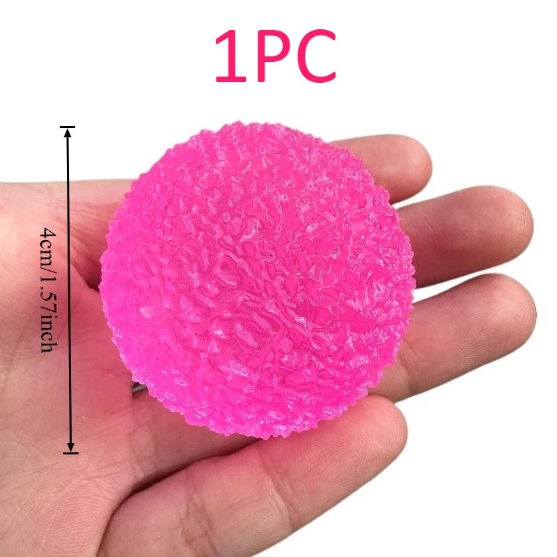 Pink textured stress ball held in a hand with dimensions indicated, on a white background
