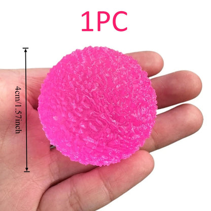 Pink textured stress ball held in a hand with dimensions indicated, on a white background