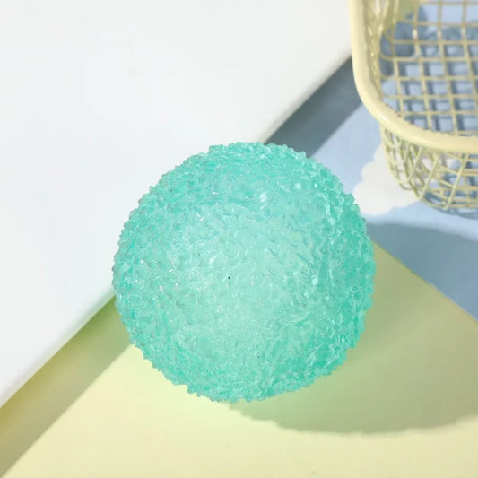 green textured stress ball on a light surface with a basket in the background
