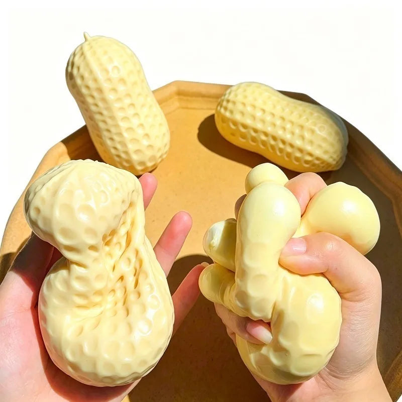 Hands holding yellow peanut-shaped stress relievers on a wooden surface