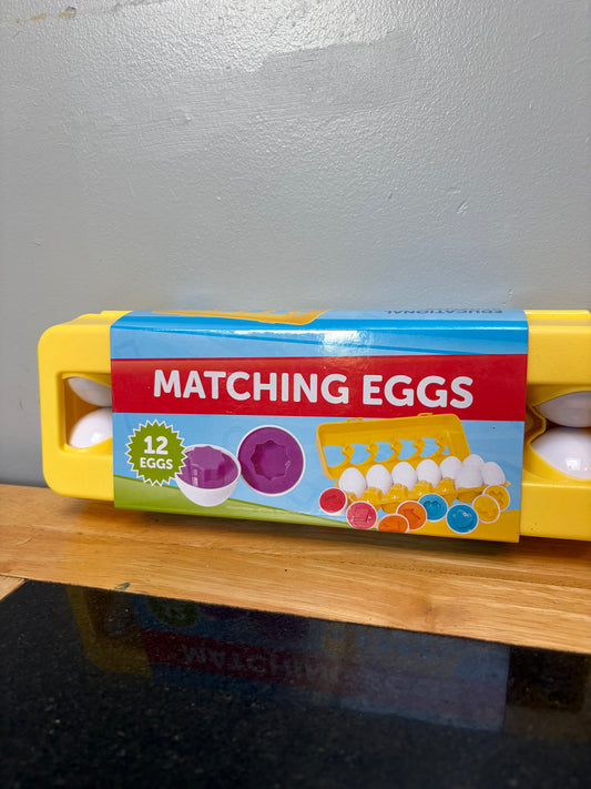 Set of 12 matching shape and color toy eggs in yellow carton, close up view